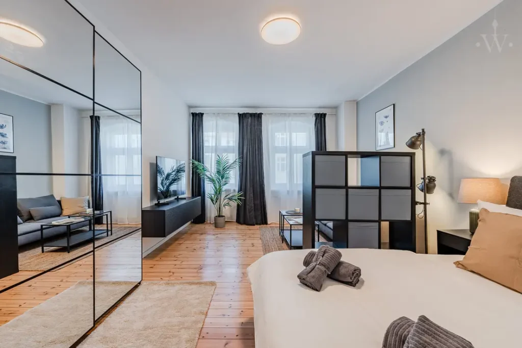 Schlafzimmer mit Doppelbett, Glas-Trennwand/Schrank, Teppich und bodentiefen Fenstern.