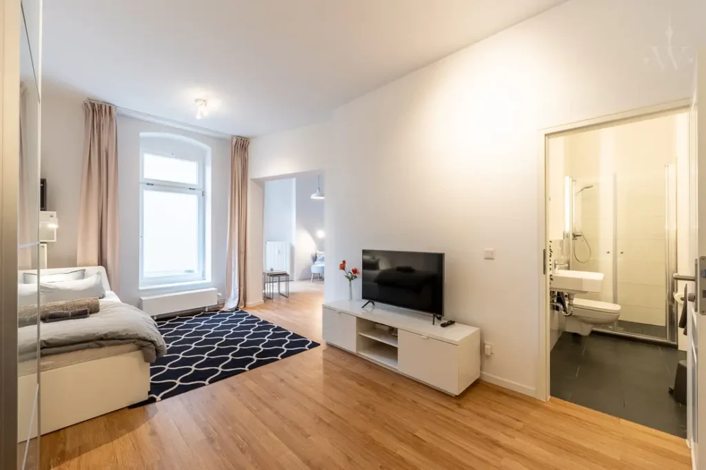 The bed, carpet and a television with a cabinet are in the picture.