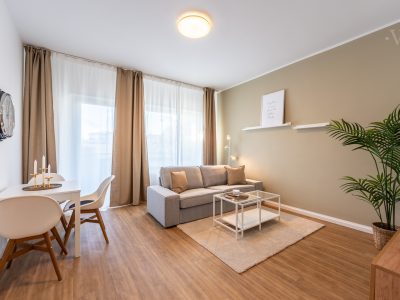 Luftiger Wohnraum mit großem Fenster und gemütlichem Sofa im WOONWOON Apartment